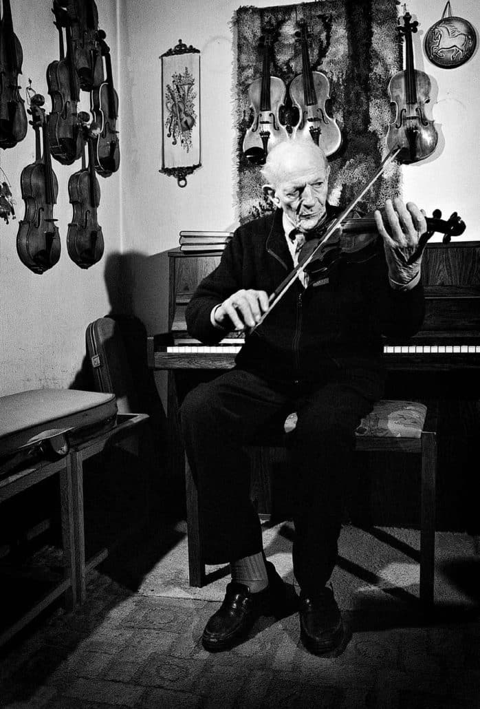 gammel mand spiller på en af hans 10 hjemmebyggede violiner